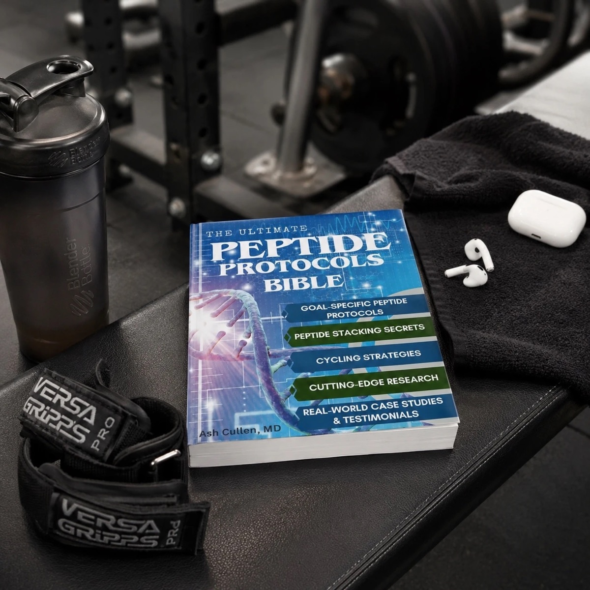 Peptide Protocols Bible on a gym bench beside a shaker bottle and lifting straps
